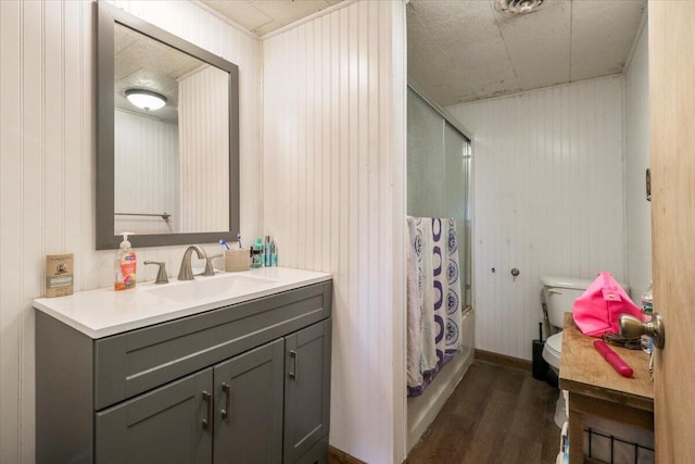 bathroom with vanity, wood walls, curtained shower, hardwood / wood-style flooring, and toilet