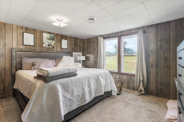 carpeted bedroom featuring wooden walls