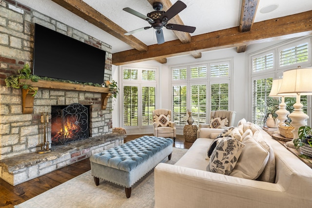 sunroom / solarium featuring a fireplace, ceiling fan, and beamed ceiling