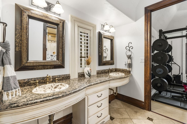 full bathroom featuring double vanity, tile patterned floors, baseboards, and a sink
