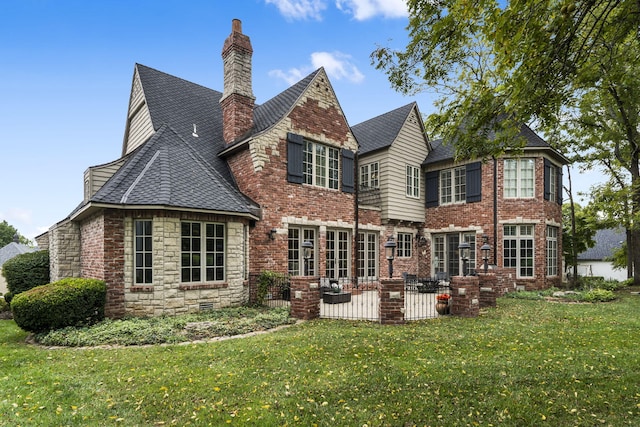 rear view of house with a yard, a patio area, roof with shingles, and a chimney