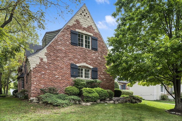 view of side of home with a lawn and brick siding