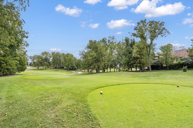 surrounding community with a yard and view of golf course