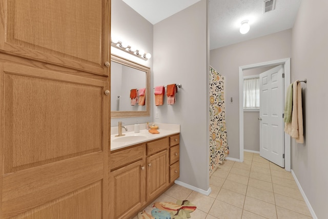 bathroom with vanity, tile patterned flooring, and a textured ceiling