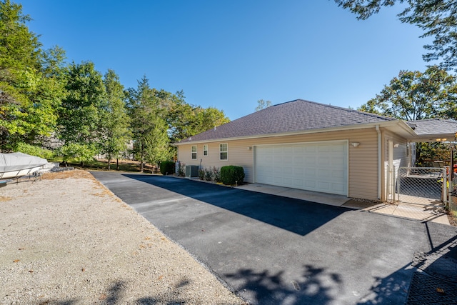 exterior space with a garage and central AC