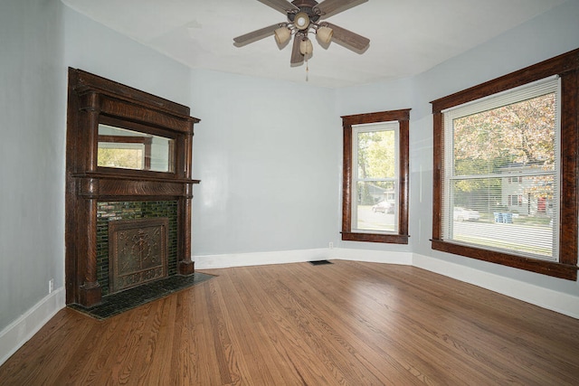 unfurnished living room with ceiling fan and wood-type flooring