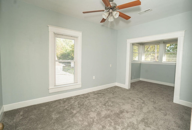 carpeted spare room with ceiling fan