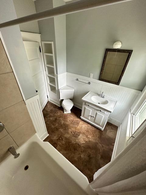 bathroom with walk in shower, vanity, and toilet