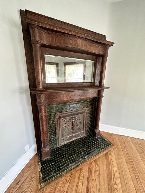 interior details with hardwood / wood-style flooring and a tiled fireplace