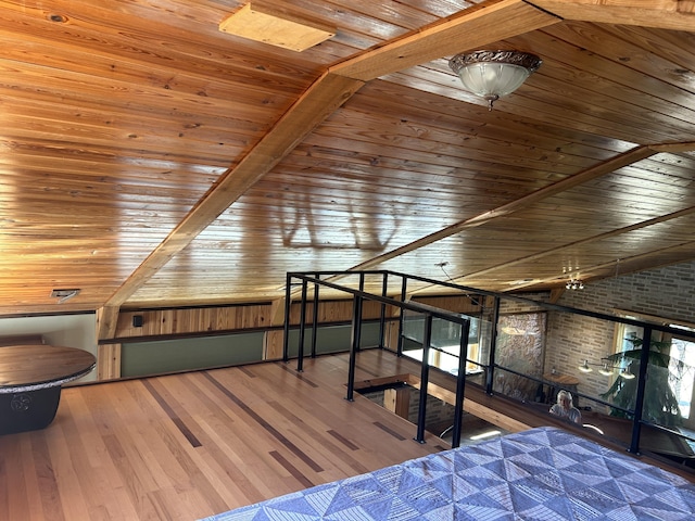 unfurnished bedroom featuring brick wall, wood ceiling, vaulted ceiling with beams, and wood finished floors
