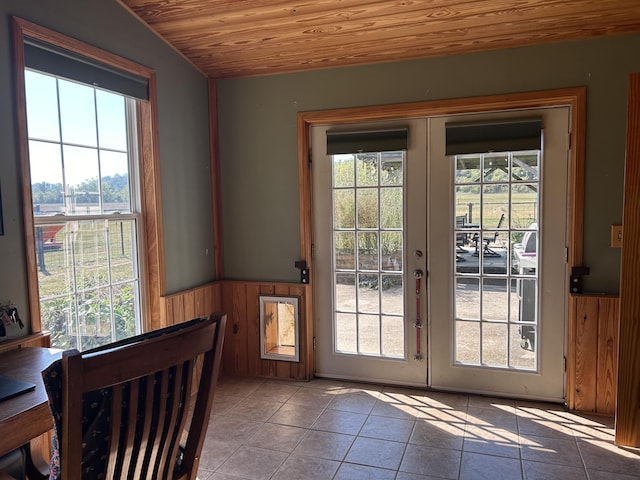 doorway to outside featuring wooden ceiling, wainscoting, and a healthy amount of sunlight