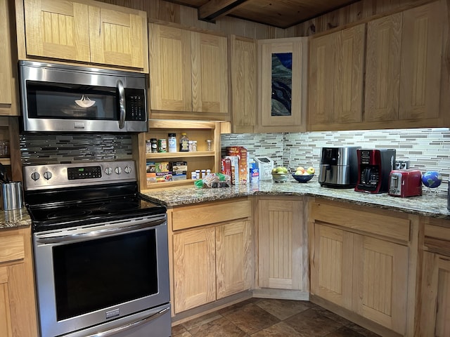 kitchen featuring glass insert cabinets, light brown cabinets, appliances with stainless steel finishes, light stone countertops, and backsplash