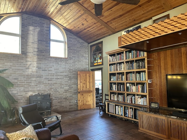 sitting room with ceiling fan, high vaulted ceiling, wooden ceiling, and brick wall