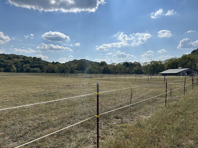 view of yard featuring fence and a rural view