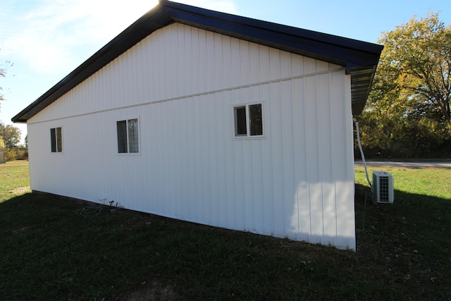 view of side of property with cooling unit and a lawn