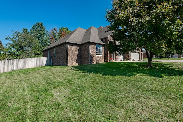 view of side of home with a yard and a garage