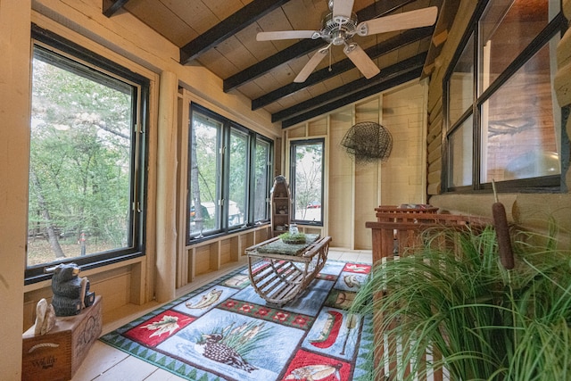 sunroom / solarium featuring ceiling fan, plenty of natural light, and lofted ceiling with beams