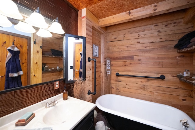 bathroom featuring vanity, wood walls, and a tub