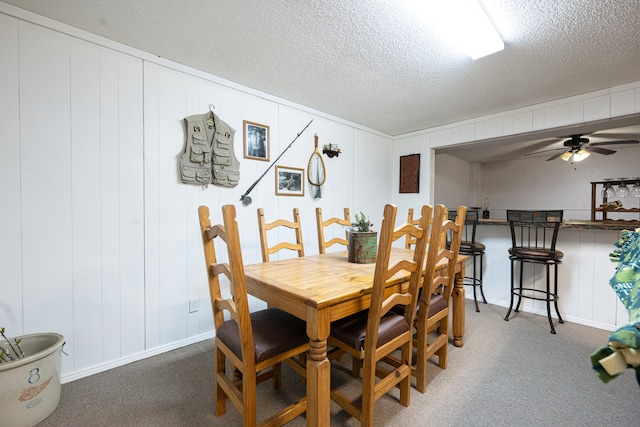 dining room featuring ceiling fan, a textured ceiling, and carpet