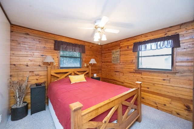 carpeted bedroom with wooden walls and ceiling fan