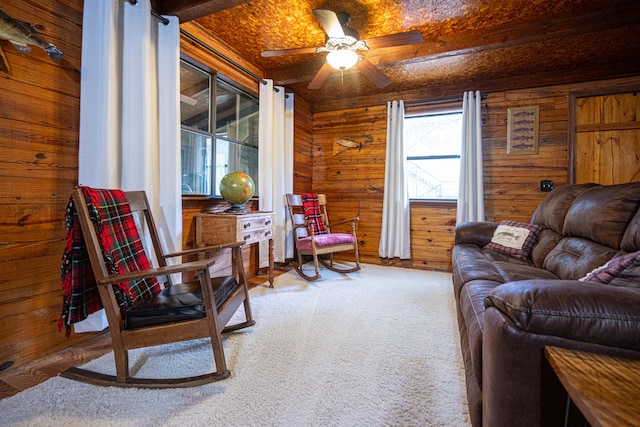 living room featuring wood walls, carpet floors, and ceiling fan