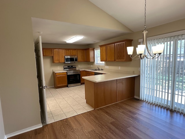 kitchen with kitchen peninsula, light hardwood / wood-style floors, sink, and stainless steel appliances