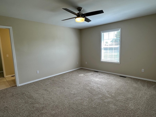 spare room featuring ceiling fan and light carpet