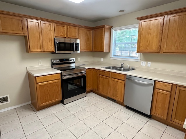 kitchen featuring light tile patterned floors, stainless steel appliances, and sink