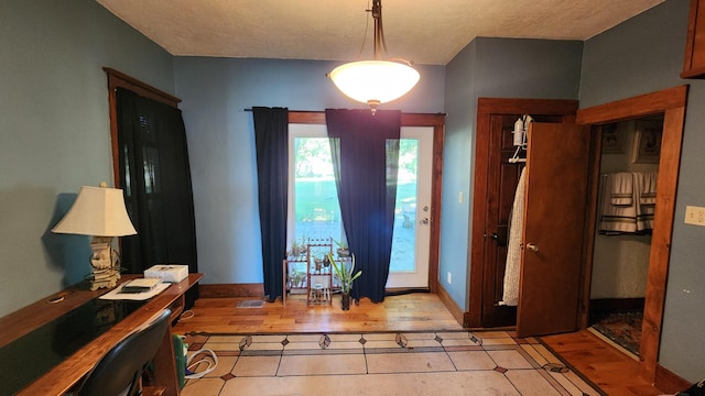 foyer with a textured ceiling and light hardwood / wood-style flooring