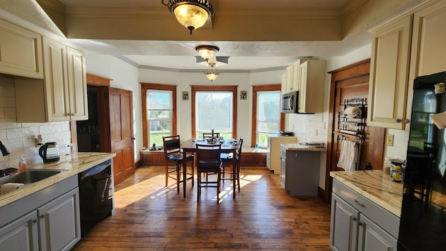 kitchen with gray cabinetry, black appliances, hardwood / wood-style floors, and backsplash