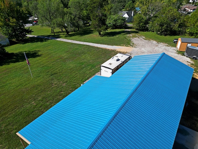 view of swimming pool with a lawn and a storage unit