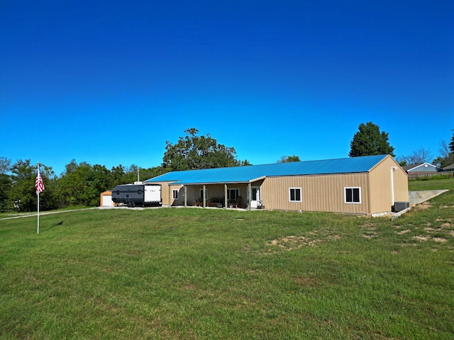 back of property with a garage and a lawn