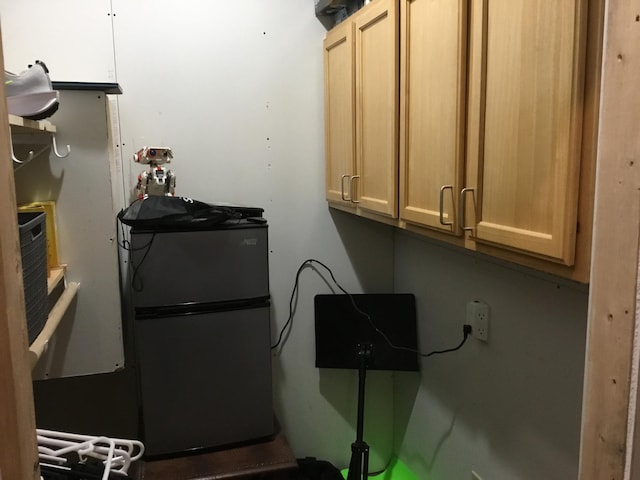 interior space featuring light brown cabinets and refrigerator