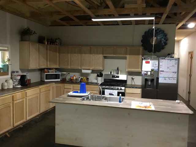 kitchen with light brown cabinetry, stainless steel appliances, sink, and butcher block counters