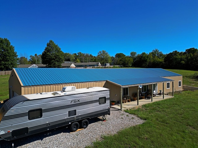 rear view of house featuring a lawn and a patio area