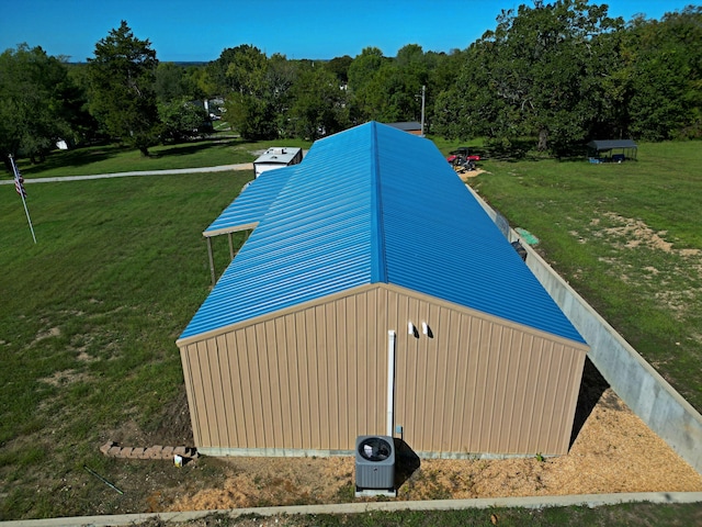 exterior space featuring central AC unit and a yard