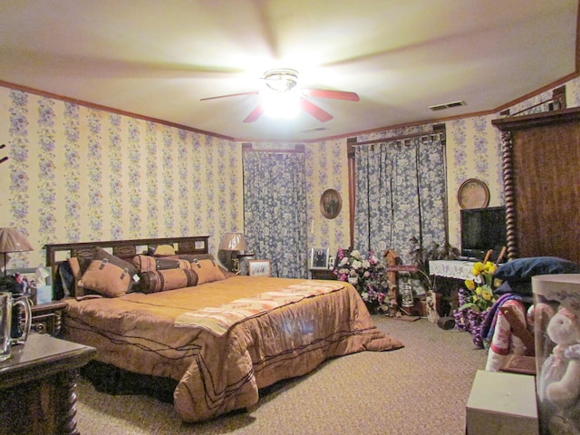 carpeted bedroom with ceiling fan, crown molding, wallpapered walls, and visible vents