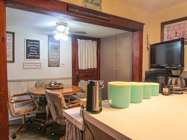 dining room with ceiling fan and wood walls