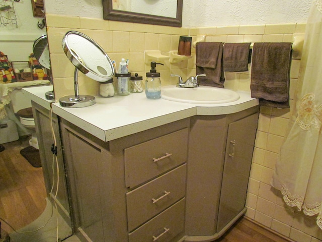 bathroom featuring vanity, tile walls, and hardwood / wood-style flooring