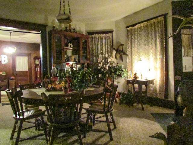 carpeted dining area featuring a notable chandelier