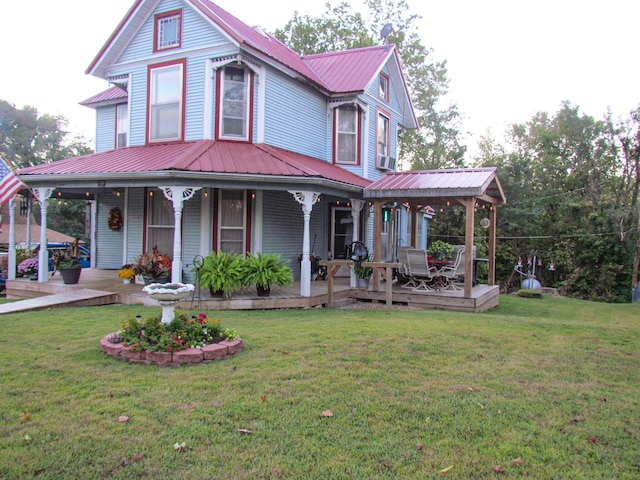 view of front facade with a porch, a front yard, and metal roof