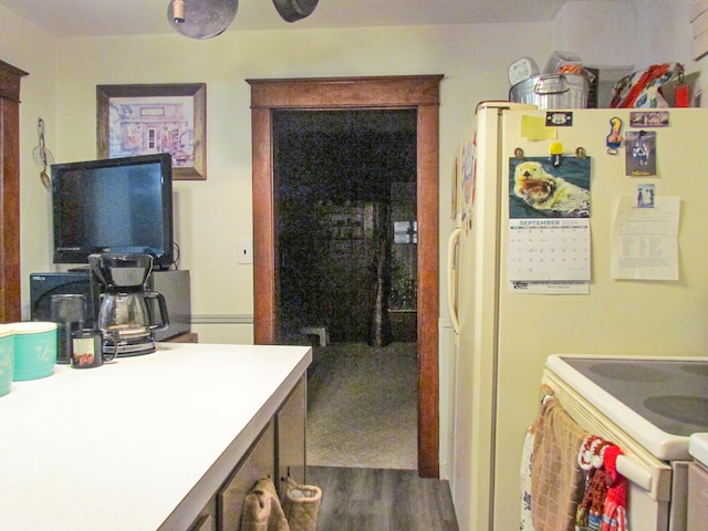 kitchen featuring light countertops, white appliances, and dark wood finished floors