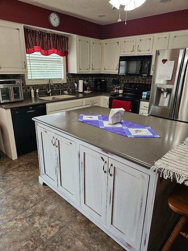 kitchen featuring black appliances, white cabinetry, sink, and tasteful backsplash