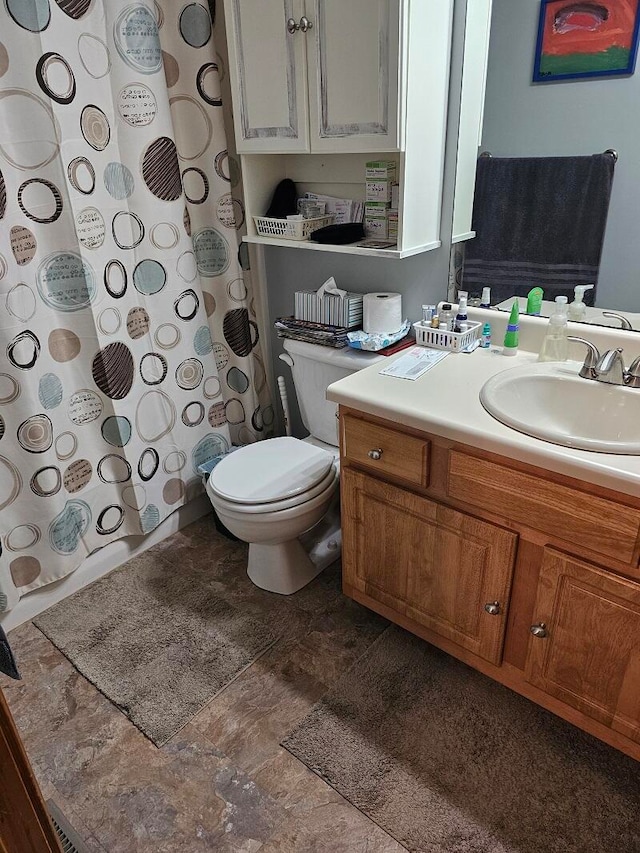 bathroom featuring toilet, walk in shower, and vanity