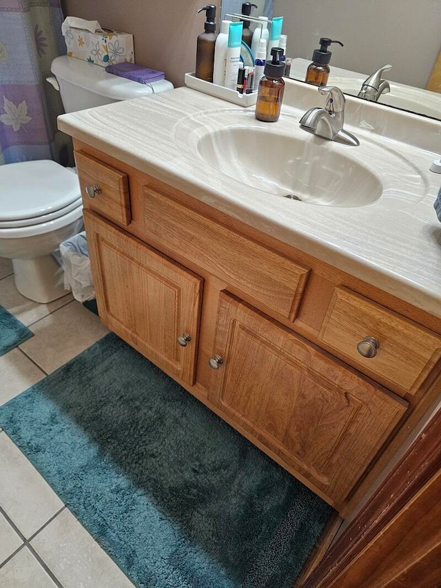 bathroom featuring toilet, tile patterned flooring, and vanity