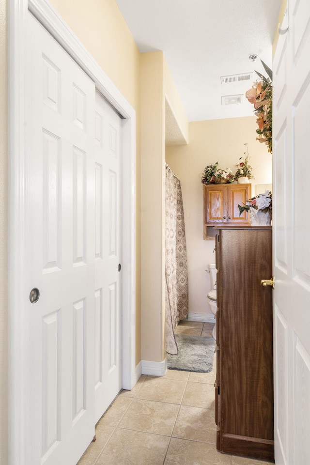 hall with light tile patterned floors