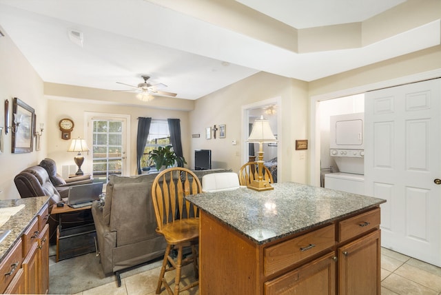 180 Grace Chapel Rd Unit 246, Blue Eye, MO 65611 - kitchen featuring brown cabinets, stacked washing maching and dryer, open floor plan, and a breakfast bar area