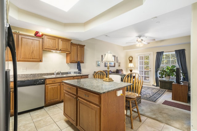 kitchen with ceiling fan, light tile patterned floors, sink, appliances with stainless steel finishes, and a center island