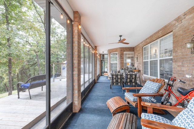 sunroom / solarium featuring ceiling fan