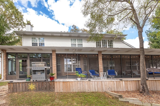 rear view of property featuring a sunroom and a patio